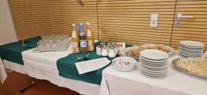 Buffet mit Getränken und Gebäck in Konferenzraum.