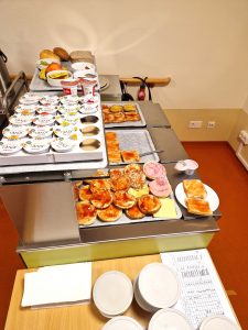 Buffet mit Brot, Aufschnitt, Joghurt und Obst.