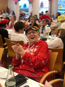 Frohes Karnevalsfest mit lachenden Senioren in bunten Kostümen.