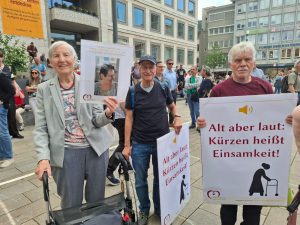 Senioren demonstrieren mit Schildern gegen Kürzungen