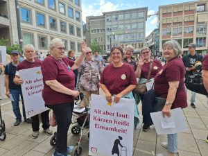 Ältere Demonstrierende mit Protestplakaten in der Innenstadt