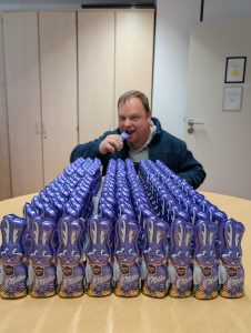 Mann beißt in Schokoladenhasen
