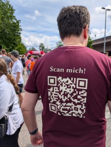 Mann mit QR-Code-Shirt in Menschenmenge