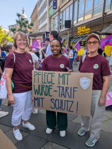 Drei Frauen mit Protestplakat bei Demonstration