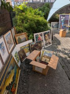 Gerahmte Bilder und Kartons in sonnigem Hinterhof